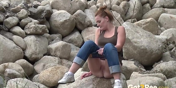 redhead pissing a sexy european babe pees over rocks while outside